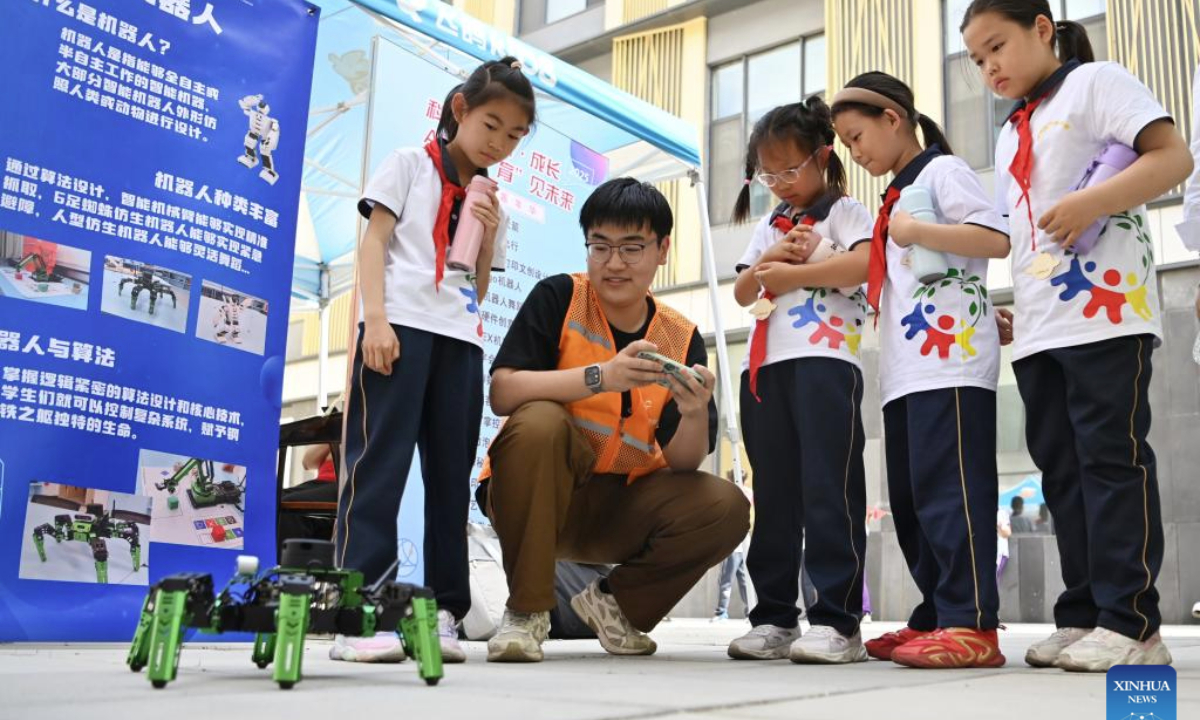 Primary school students learn about a robot at Tianjin Normal University in north China's Tianjin, May 15, 2025. A cultural festival featuring science and innovation kicked off on Thursday at Tianjin Normal University. Students from nine primary schools in Tianjin participated in a science market and watched science plays at the event. (Xinhua/Li Ran)
