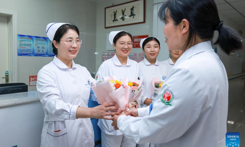 A doctor presents flowers to a nurse at a mental health center in Zaozhuang, east China's Shandong Province, May 10, 2025. International Nurses Day, which falls annually on May 12, have recently been observed across China in various forms. (Photo by Wang Longfei/Xinhua)