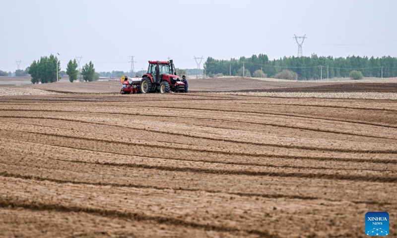 Farmers operate a tractor equipped with Beidou navigation system for sowing in Horqin Left Wing Rear Banner of Tongliao City, north China's Inner Mongolia Autonomous Region, on May 9, 2025. (Xinhua/Lian Zhen)
