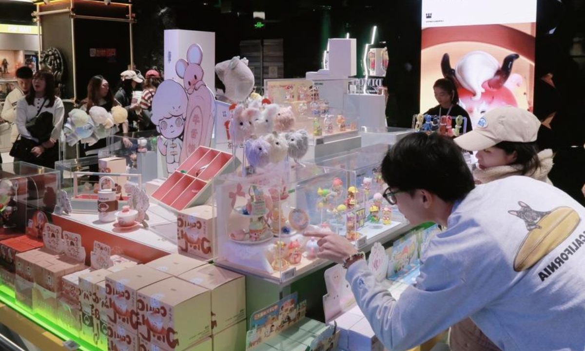 Consumers select blind boxes at a Pop Mart store in Xidan Joy City, a shopping mall in Beijing, capital of China, Dec. 28, 2024. (Xinhua/Shi Yifei)