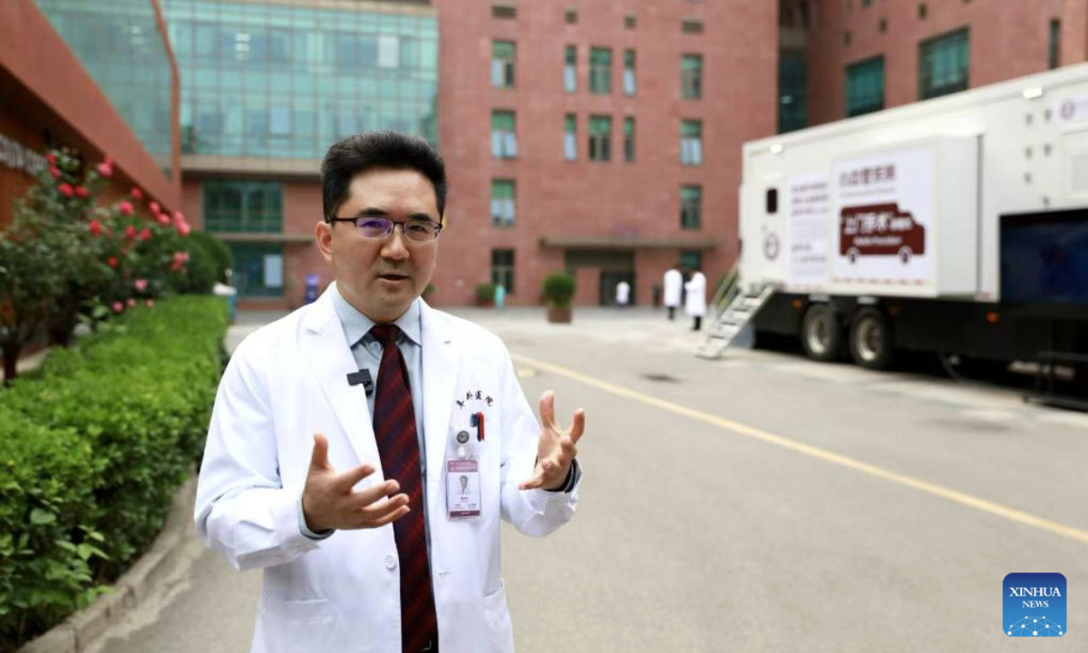 Pan Xiangbin, vice president and professor of the Beijing-based Fuwai Hospital, Chinese Academy of Medical Sciences, introduces a mobile operation vehicle carrying echocardiography and anesthesia machines of his hospital in Beijing, capital of China, May 18, 2025.(Xinhua/Fang Sixian)