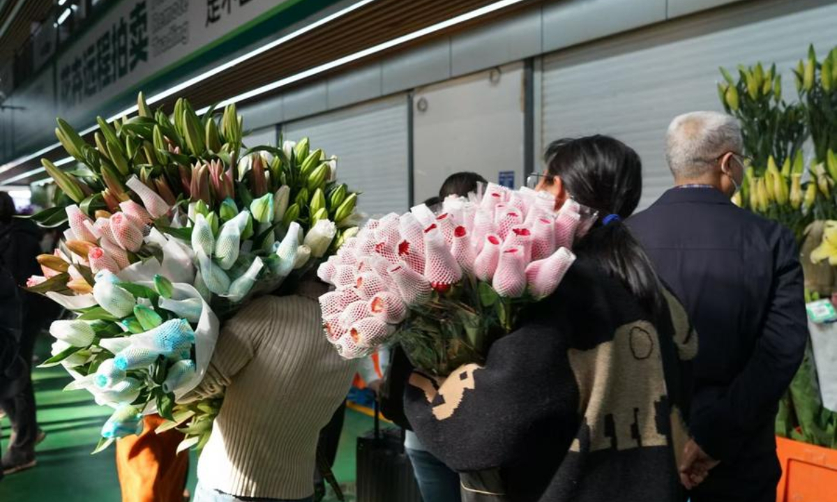 Shoppers walk with flowers at Dounan Flower Market in Kunming, southwest China's Yunnan Province, March 5, 2025. (Xinhua/Yi Jiaxin)