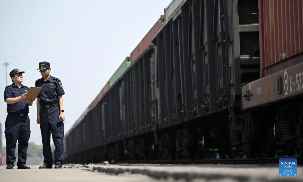 Customs staff members check a China-Central Asia freight train at a train station at Tianjin Port in north China's Tianjin, May 20, 2025. The first China-Central Asia freight train from Tianjin Port to Tashkent via Horgos in 2025 departed here on Tuesday, sending fifty containers of auto parts, mechanical equipment, building materials and household appliances to Uzbekistan's capital. (Xinhua/Zhao Zishuo)