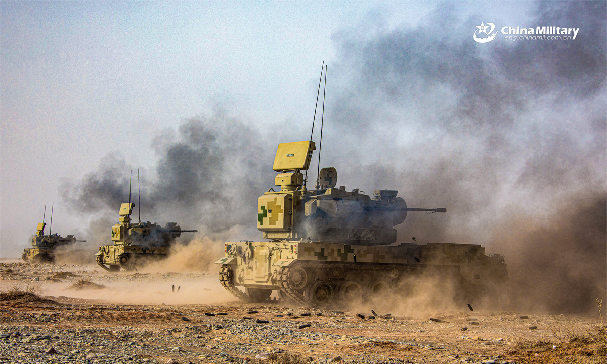 PGZ-09 dual 35mm wheeled self-propelled anti-aircraft gun systems (SPAAG) attached to an air-defense unit with a combined-arms regiment under the Chinese PLA Xinjiang Military Command maneuver in smoke, kicking off a cloud of dust, during a live-fire training exercise in early May, 2025. (eng.chinamil.com.cn/Photo by Feng Kesheng)