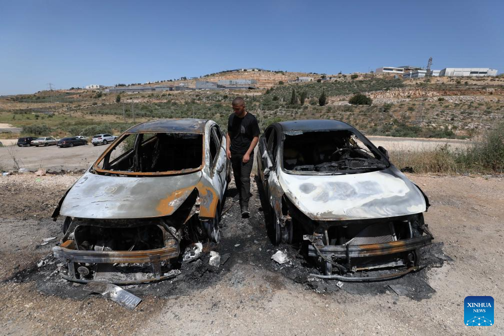 A Palestinian checks cars burned by Israeli settlers near the West Bank city of Salfit, May 16, 2025. (Photo by Nidal Eshtayeh/Xinhua)