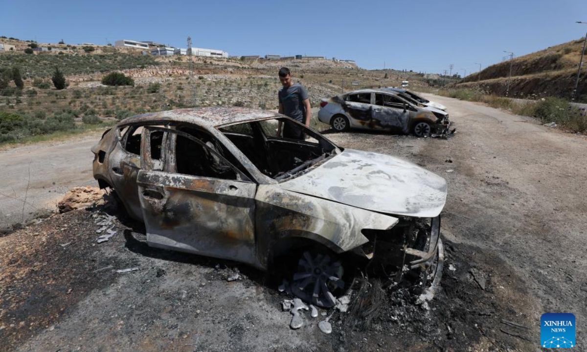 A Palestinian checks cars burned by Israeli settlers near the West Bank city of Salfit, May 16, 2025. (Photo by Nidal Eshtayeh/Xinhua)