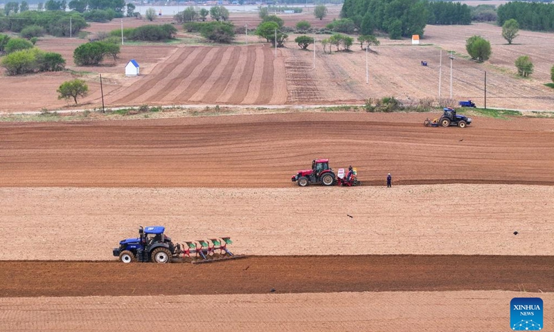An aerial drone photo taken on May 9, 2025 shows farmers operating tractors equipped with Beidou navigation system in the fields in Horqin Left Wing Rear Banner of Tongliao City, north China's Inner Mongolia Autonomous Region. (Xinhua/Lian Zhen)