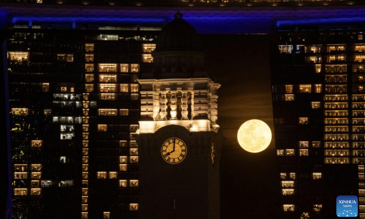 A full moon rises behind the clock tower of the Victoria Theatre and Victoria Concert Hall in Singapore on May 13, 2025. (Xinhua/Then Chih Wey)