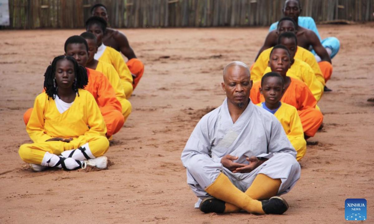 Damien Agossou Degbo (front) meditates with his students at his martial arts club in Akpro-Misserete, a town some 40 kilometers northeast of Benin's economic capital Cotonou, on May 18, 2025.(Photo by Seraphin Zounyekpe/Xinhua)