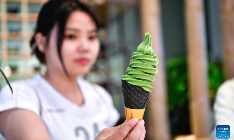 A customer shows a matcha-flavored ice cream at a store in Jiangkou County, southwest China's Guizhou Province, May 15, 2025. Located at the foot of Mount Fanjing, a UNESCO World Heritage Site, Jiangkou County is a powerhouse in the world's matcha industry. The geographical and climatic advantages such as high altitude, low latitude, abundant fog and limited sunlight, make Jiangkou an ideal place for tea growing. (Photo: Xinhua)