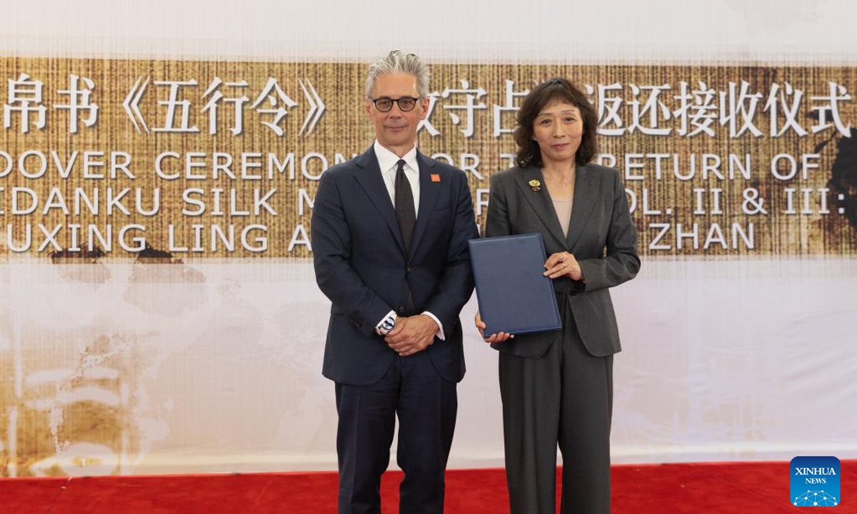 Zhu Ye (R), deputy director-general of Office for the Recovery and Restitution of Lost Cultural Property, National Cultural Heritage Administration of China, receives a certificate of transfer from Chase F. Robinson, director of the Smithsonian's National Museum of Asian Art, during a handover ceremony of the ancient Zidanku Silk Manuscripts from the Warring States period at the Chinese Embassy in the United States in Washington, D.C., on May 16, 2025. Photo: Xinhua
