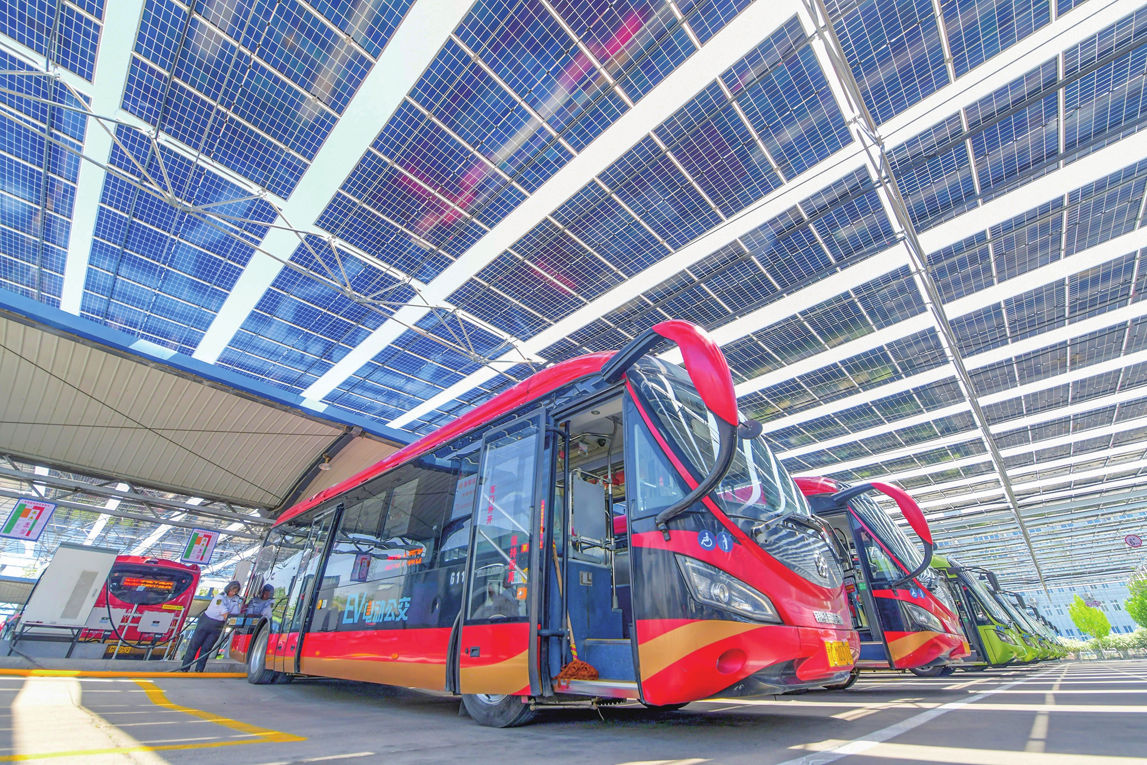 A driver charges a bus on May 19, 2025 in Luoyang, Central China's Henan Province as a photovoltaic power generation project is officially put into use. The project covers an overall area of 11,000 square meters and has made full use of the space above the bus parking lot to install photovoltaic modules.