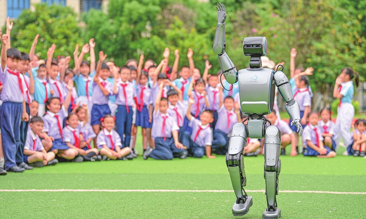 Students interact with a humanoid robot at a primary school in Ganzhou, East China's Jiangxi Province on May 19, 2025. An industry report shows that China's humanoid robot market is estimated to hit 5.3 billion yuan ($735.141 million) in 2025, double the size in 2024. 
Photo: VCG