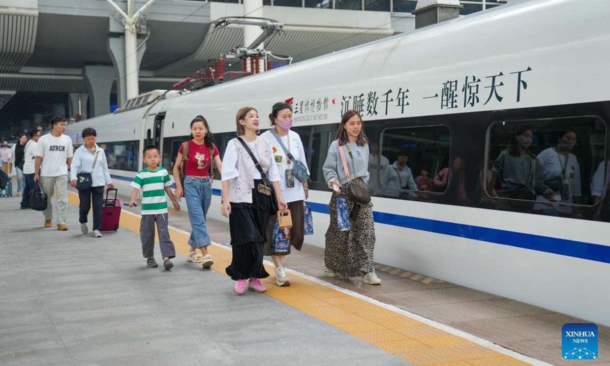 Passengers board a Sanxingdui-themed train at Chengdu East Railway Station in Chengdu, southwest China's Sichuan Province, May 18, 2025. The tourist train left Chengdu on Sunday, marking the launch of the first train themed around the legendary Sanxingdui Ruins site.(Photo: Xinhua)