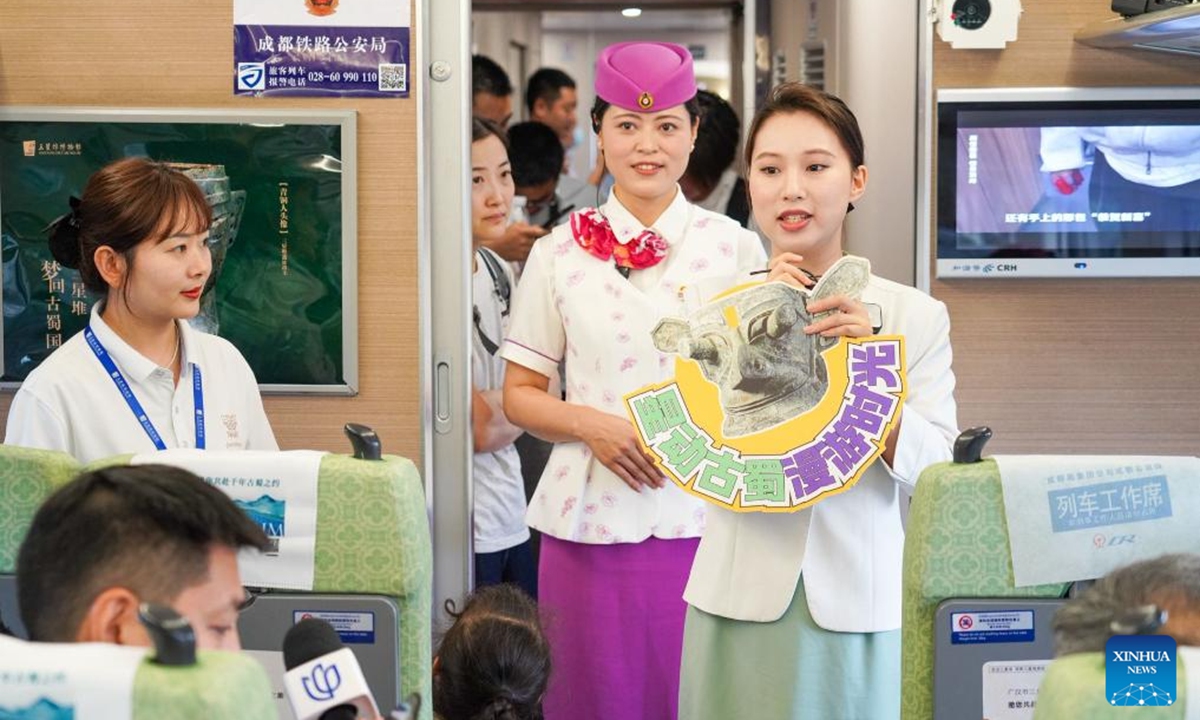 A docent from Sanxingdui Museum is pictured on a Sanxingdui-themed train linking Chengdu, Sanxingdui Ruins and Jiuzhai Valley in southwest China's Sichuan Province, May 18, 2025. The tourist train left Chengdu on Sunday, marking the launch of the first train themed around the legendary Sanxingdui Ruins site.(Photo: Xinhua)
