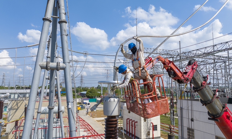 Workers install connecting wires for the main transformer equipment at a 500-kilovolt substation in Zhenjiang, East China's Jiangsu Province on May 20, 2025. The upgrade project aims to significantly enhance regional power supply capabilities to meet the peak summer demand, providing robust support for high-quality economic and social development. Photo: VCG
