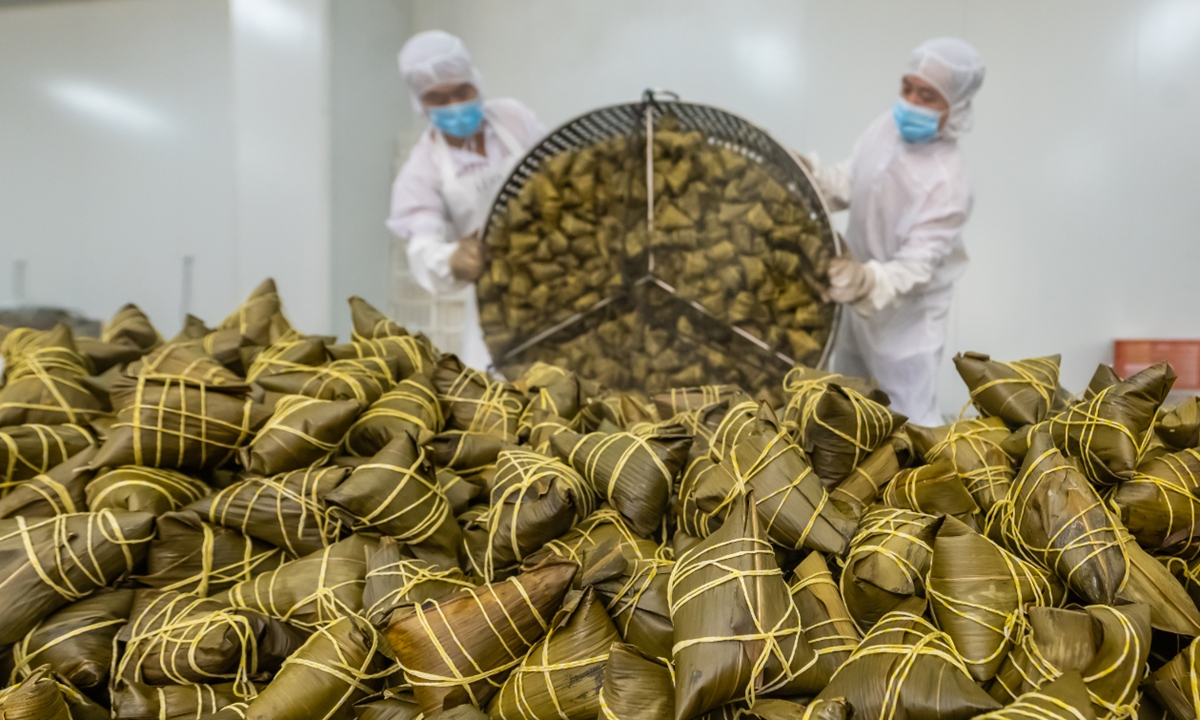 Workers in a food processing factory work to produce locally distinctive flavored zongzi, a glutinous rice dumpling wrapped in bamboo or reed leaves, on May 21, 2025 in Zigui, Central China's Hubei Province. Duanwu, or the Dragon Boat Festival, is celebrated on the fifth day of the fifth month of the traditional Chinese calendar, which falls on May 31 in 2025, to commemorate ancient Chinese poet Qu Yuan from the Warring States Period (475BC-221BC). Photo: VCG