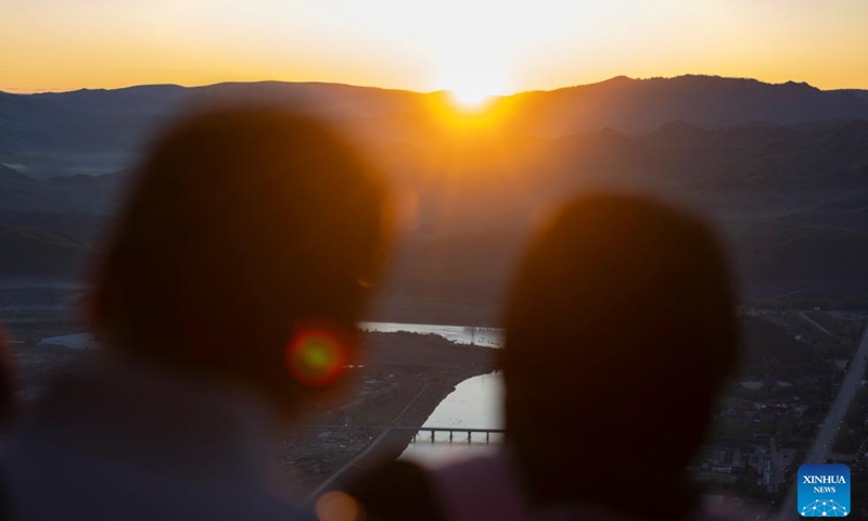 Tourists enjoy the sunrise at the Jinzu Peak in Yichun, northeast China's Heilongjiang Province, May 21, 2025. Jinzu Peak scenic area attracts numerous tourists with its stunning sunrise and sea of clouds. (Xinhua/Xie Jianfei)