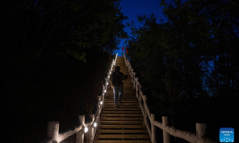 A tourist hikes to Jinzu Peak to watch the sunrise in Yichun, northeast China's Heilongjiang Province, May 21, 2025. Jinzu Peak scenic area attracts numerous tourists with its stunning sunrise and sea of clouds. (Xinhua/Xie Jianfei)