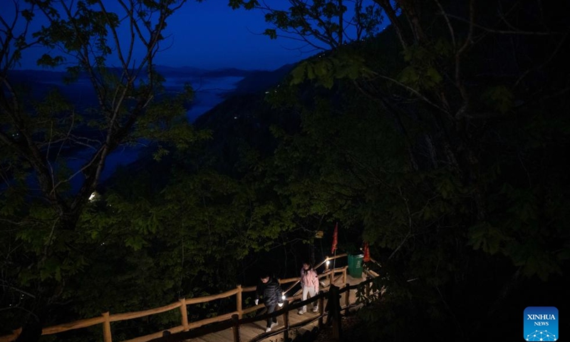 Tourists hike to Jinzu Peak to watch the sunrise in Yichun, northeast China's Heilongjiang Province, May 21, 2025. Jinzu Peak scenic area attracts numerous tourists with its stunning sunrise and sea of clouds. (Xinhua/Xie Jianfei)