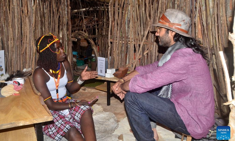 An exhibitor (L) talks to a visitor in the exhibited hut at the three-day Pearl of Africa Tourism Expo in Kampala, Uganda, on May 21, 2025. The annual Pearl of Africa Tourism Expo, Uganda's premium tourism show, opened here on Wednesday as the East African country strives to boost tourist arrivals. (Photo by Nicholas Kajoba/Xinhua)