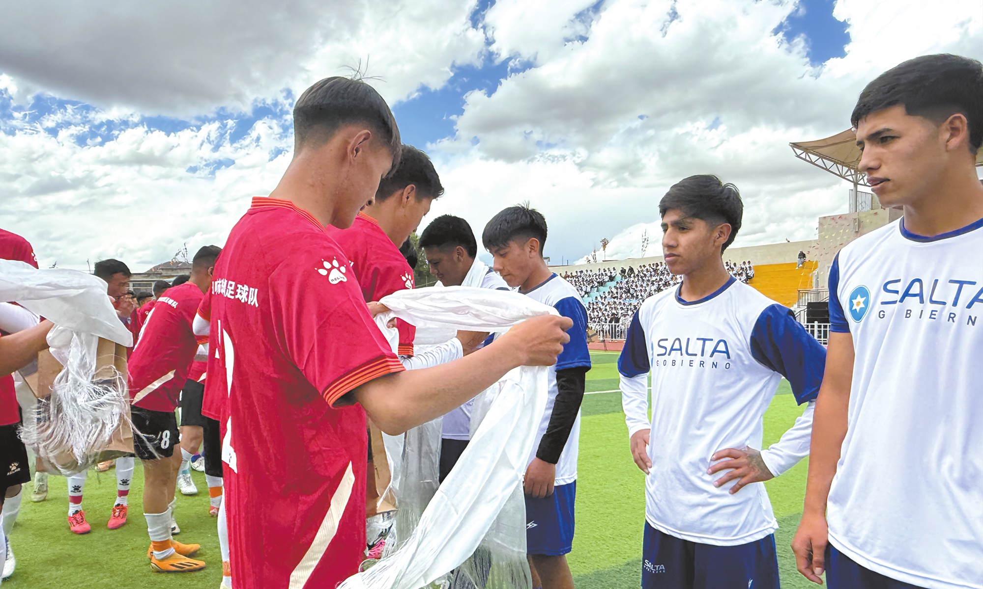 Players from Xigaze present Khatas, a ceremonial white scarf symbolizing goodwill and blessings, to visiting Argentine players before the football match in Xigaze on May 20, 2025. 