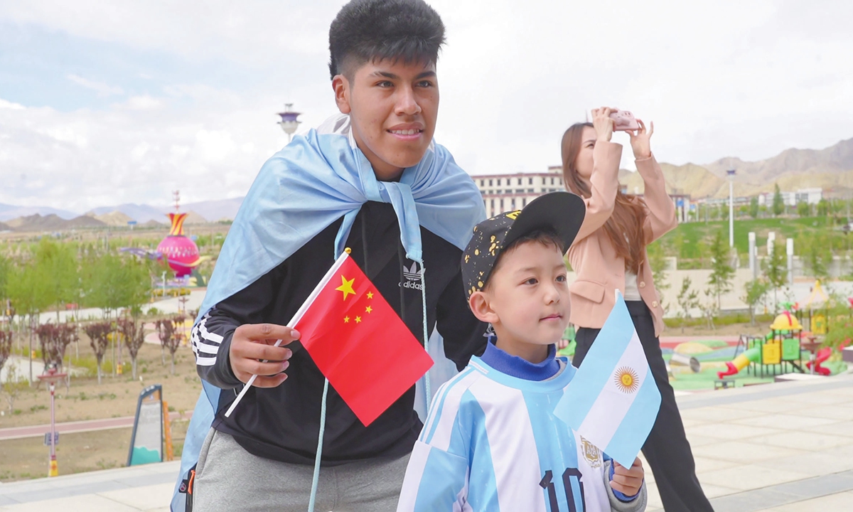 An Argentine youth poses for a photo with a young local fan wearing a Messi jersey during a sightseeing tour in Xigaze on May 19, 2025.
