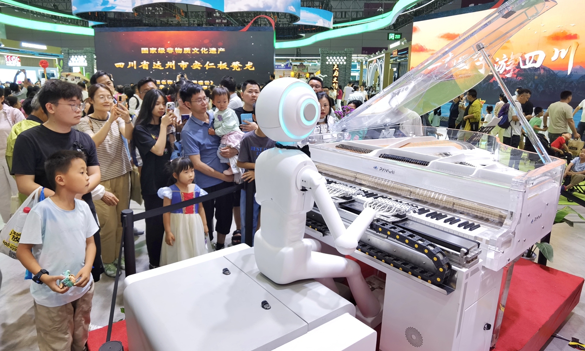 Locals watch a robot play the piano as they visit the 21st China (Shenzhen) International Cultural Industries Fair at  Shenzhen World Exhibition & Convention Center, Guangdong Province, on May 25, 2025. Photo: VCG
