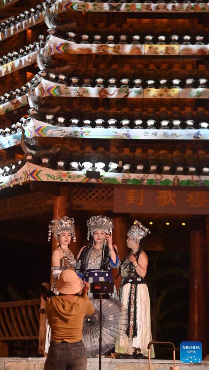 Tourists take photos at Mengwu Miao Village in Rongshui Miao Autonomous County of Liuzhou City, south China's Guangxi Zhuang Autonomous Region, April 15, 2025. In recent years, Guangxi has been continuously focusing on the upgrade of consumption experience and promoting the integration of cultural tourism and commerce. Various night fairs and booths have boosted consumption and injected vitality into the night economy. Photo: Xinhua