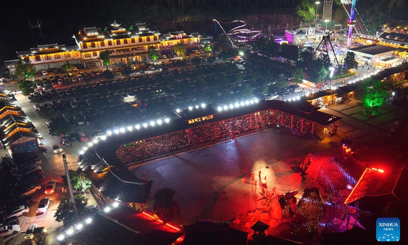 An aerial drone photo shows tourists watching a folk performance at Mengwu Miao Village in Rongshui Miao Autonomous County of Liuzhou City, south China's Guangxi Zhuang Autonomous Region, May 3, 2025. In recent years, Guangxi has been continuously focusing on the upgrade of consumption experience and promoting the integration of cultural tourism and commerce. Various night fairs and booths have boosted consumption and injected vitality into the night economy. Photo: Xinhua
