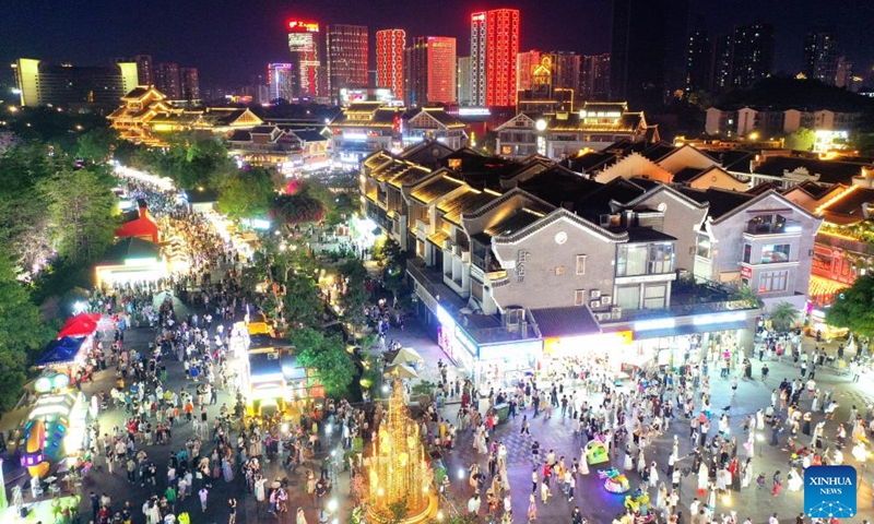 A drone photo shows people visiting Yaobu ancient town in Liuzhou, south China's Guangxi Zhuang Autonomous Region, May 3, 2025. In recent years, Guangxi has been continuously focusing on the upgrade of consumption experience and promoting the integration of cultural tourism and commerce. Various night fairs and booths have boosted consumption and injected vitality into the night economy. Photo: Xinhua