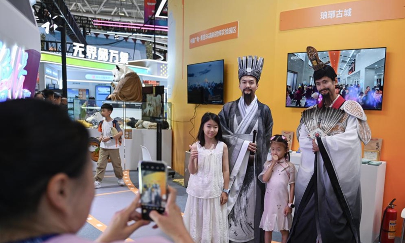 Children pose for a photo with models at the exhibition area of Shandong Province during the 21st China (Shenzhen) International Cultural Industries Fair in Shenzhen, south China's Guangdong Province, May 24, 2025. Opened here on Thursday, the five-day event is being held across eight exhibition halls -- three comprehensive spaces and five specialized areas. Activities related to traditional culture and cultural heritages attracted many young visitors. Photo: Xinhua