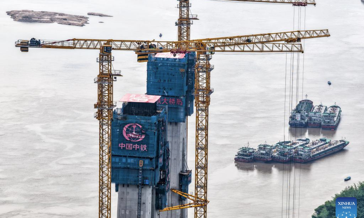 A drone photo taken on May 28, 2025 shows the construction site of Shituo Yangtze River Bridge along the Chongqing-Wanzhou high-speed railway in Chongqing, southwest China. With a height of 234.9 meters, the north main tower of the 1,056-meter bridge was successfully capped on Wednesday. (Xinhua/Tang Yi)