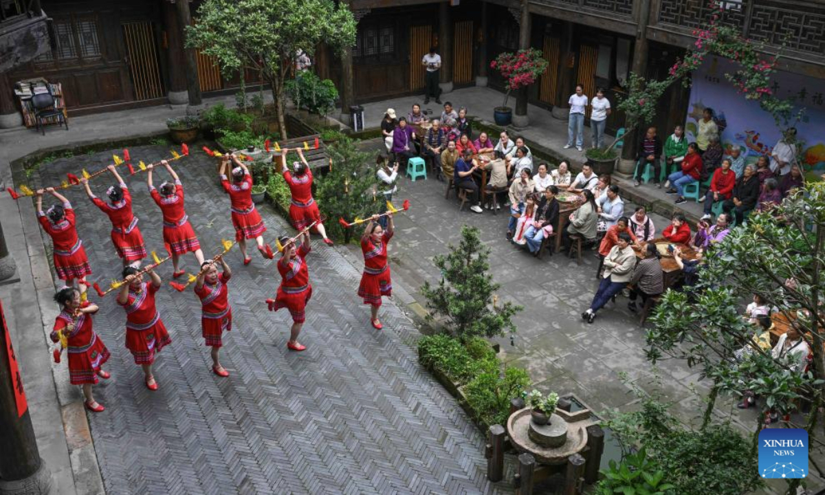 This photo taken on May 28, 2025 shows a folk dance performance at Fengsheng ancient town of Banan District in southwest China's Chongqing Municipality. Over 200 local residents and international students from Chongqing University participated in a cultural experience activity ahead of the Dragon Boat Festival, which falls on the fifth day of the fifth month in the Chinese lunar calendar. (Xinhua/Chen Cheng)