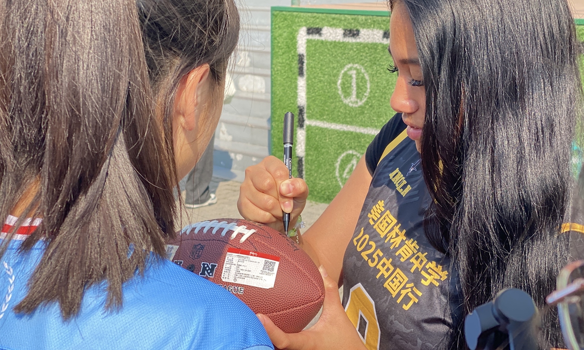 A US student signs a signature on a football during an interactive activity featuring flag football between the girls flag football team from Lincoln High School and Chinese students held at Shanghai Pinghe School on May 29, 2025. Photo: Chen Xia/GT