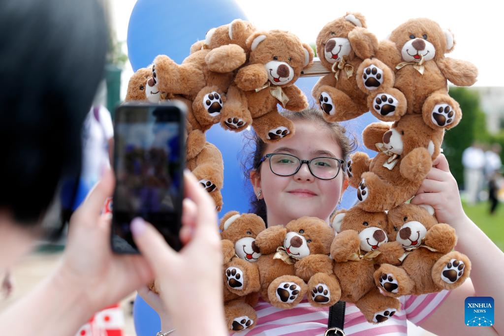 A girl poses with a decorated frame during an event marking the International Children's Day in Bucharest, Romania, June 1, 2025.  (Photo by Kaikeo Saiyasane/Xinhua)