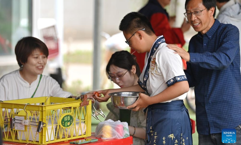 A child distributes tomatoes at Huiai Farm in Yangliuqing Town, Xiqing District, north China's Tianjin, May 31, 2025. Huiai Farm covers an area of approximately 80 mu (about 5.33 hectares) and was jointly initiated and built by 8 families, whose children were diagnosed with autism or intellectual disabilities. Huiai Farm considers farm work as a means for children to get closer to nature and encourages families to bring their children here to participate in farm work together with children with autism or intellectual disabilities, enhancing the social interaction skills of them in a real community environment. (Xinhua/Li Ran)
