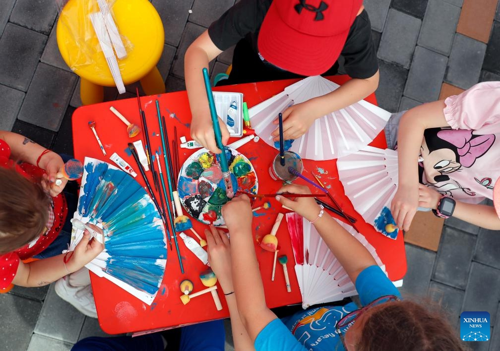 Children color white fans during an event marking the International Children's Day in Bucharest, Romania, June 1, 2025.  (Photo by Kaikeo Saiyasane/Xinhua)