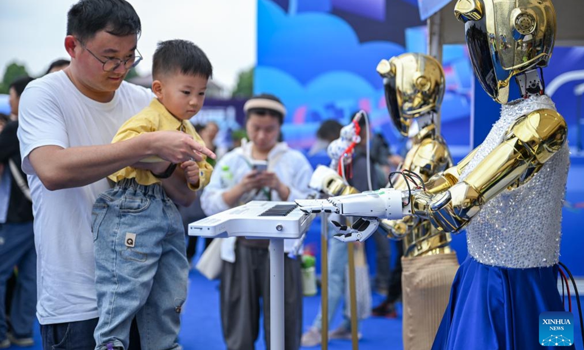 Visitors learn about a robotic bandsman during the world robot carnival in Wuhan, central China's Hubei Province, June 2, 2025. The event kicked off here on Monday, featuring nearly 100 robots including pet robots, make-up robots, robotics band, etc. People interacted with the robots to experience the charm of technology-empowered life. (Xinhua/Du Zixuan)