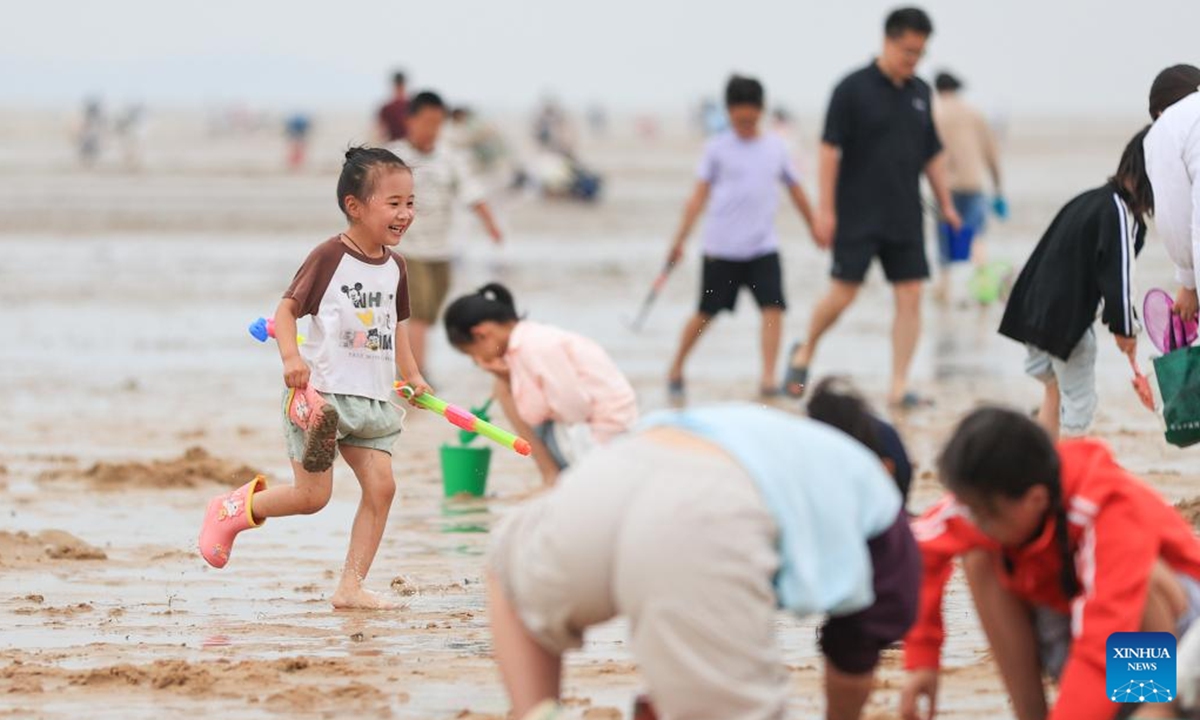 Kids have fun along the seashore of a resort in Ganyu District of Lianyungang City, east China's Jiangsu Province, June 1, 2025. People enjoy the 3-day holiday of the Dragon Boat Festival, also called Duanwu Festival which falls on May 31 this year, via various activities across the country. (Photo by Si Wei/Xinhua)