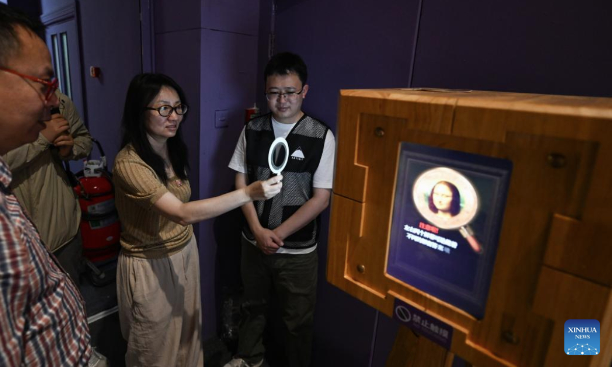 A visitor watches an image through a polarizer during the exhibition Harmony through Time and Space: How Leonardo da Vinci Created Concord between His Artistic and Scientific World and the Natural World at the Natural History Museum of China in Beijing, capital of China, June 5, 2025. The exhibition kicked off here on Thursday and will last until October 19. (Xinhua/Chen Zhonghao)