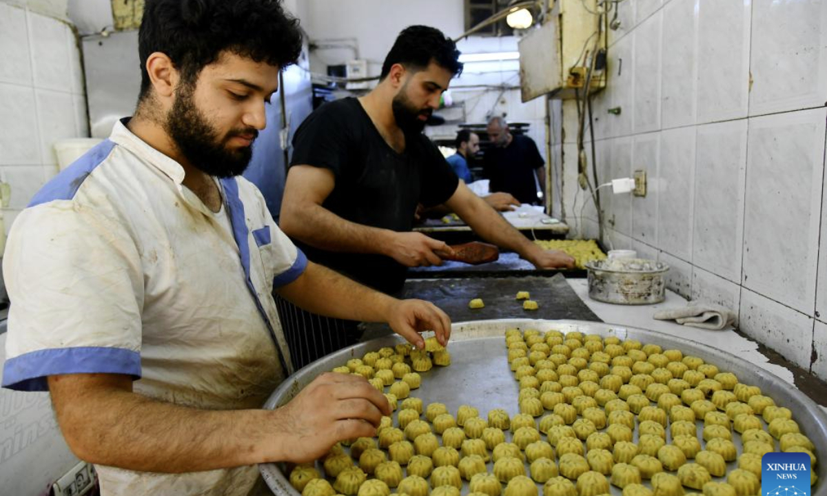 Bakers prepare cookies at a sweets shop ahead of Eid al-Adha in Damascus, Syria, on June 4, 2025. Traditional sweets are widely prepared and exchanged during Eid celebrations. (Photo by Ammar Safarjalani/Xinhua)