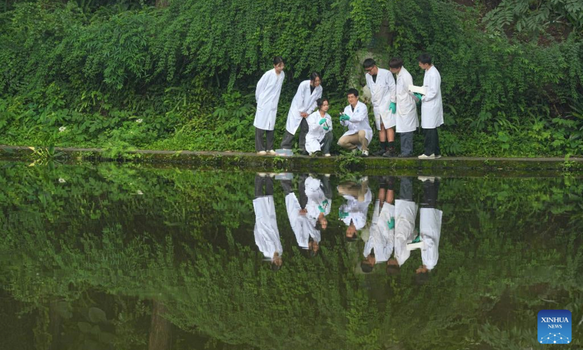 Faculty members and students of Southwest University test the water quality of a lake to find out the water situation on the campus in southwest China's Chongqing, on June 4, 2025. Various events are held to raise people's awareness of environmental protection in China ahead of World Environment Day, which falls on June 5. (Photo by Qin Tingfu/Xinhua)
