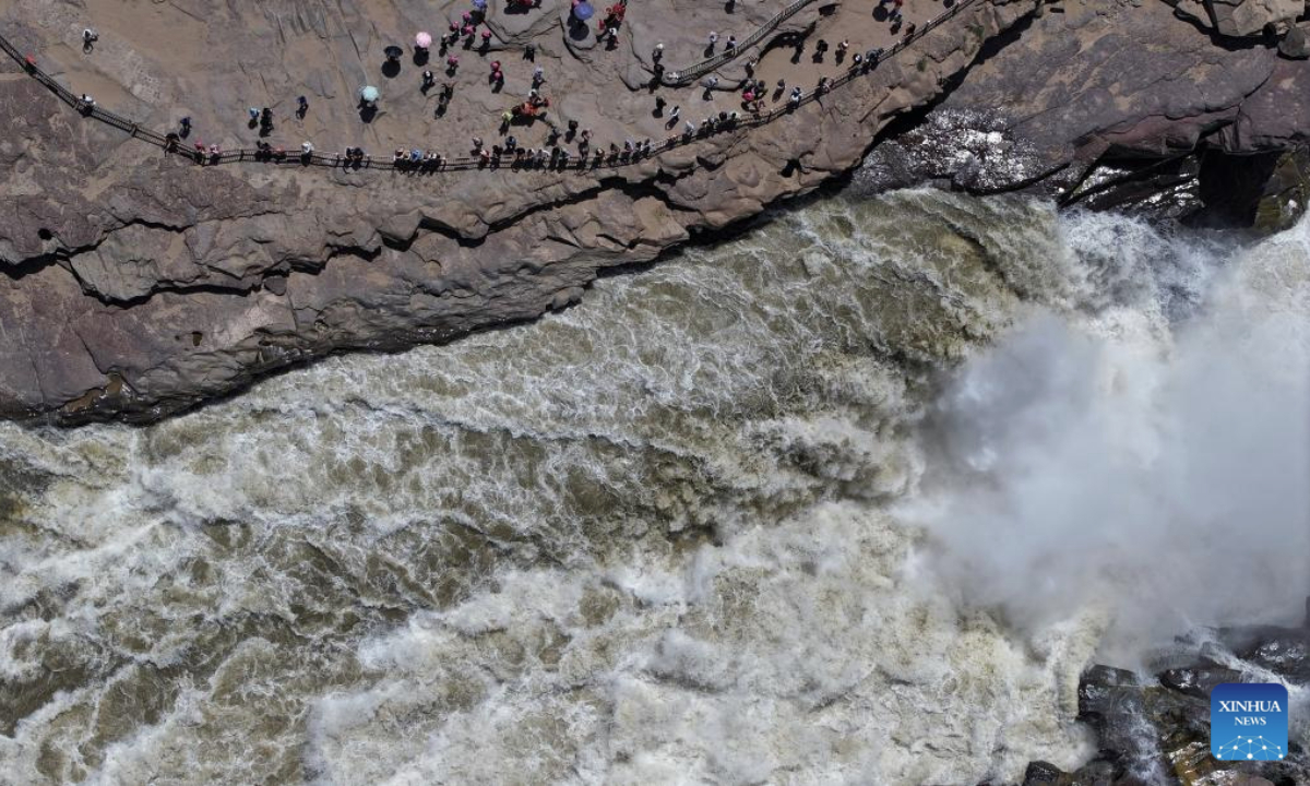 An aerial drone photo taken on June 4, 2025 shows tourists visiting the Hukou Waterfall on the Yellow River on the border between north China's Shanxi Province and northwest China's Shaanxi Province. (Xinhua/Zhang Bowen)
