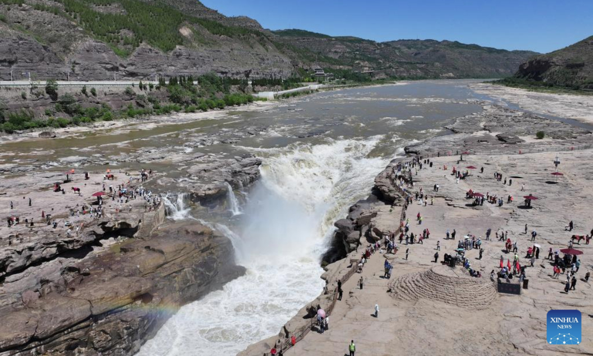 An aerial drone photo taken on June 4, 2025 shows tourists visiting the Hukou Waterfall on the Yellow River on the border between north China's Shanxi Province and northwest China's Shaanxi Province. (Xinhua/Zhang Bowen)