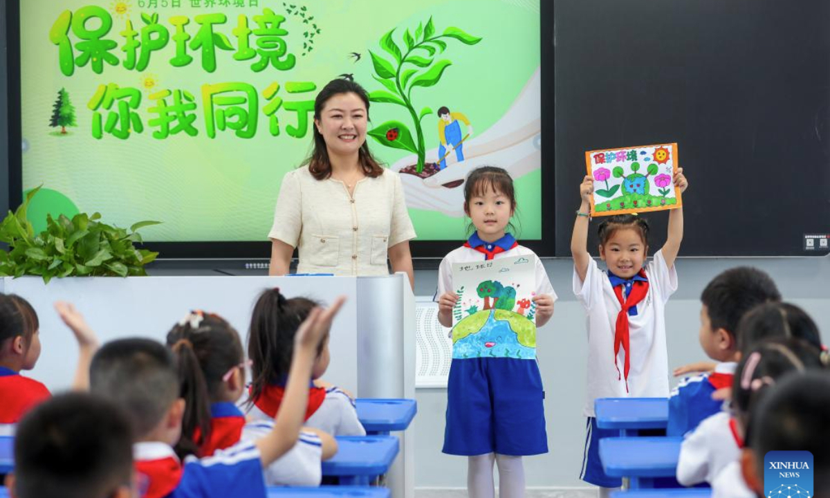 Students display paintings themed on environmental protection at a primary school in Xinghua City, east China's Jiangsu Province, on June 4, 2025. Various events are held to raise people's awareness of environmental protection in China ahead of World Environment Day, which falls on June 5. (Photo by Zhou Shegen/Xinhua)