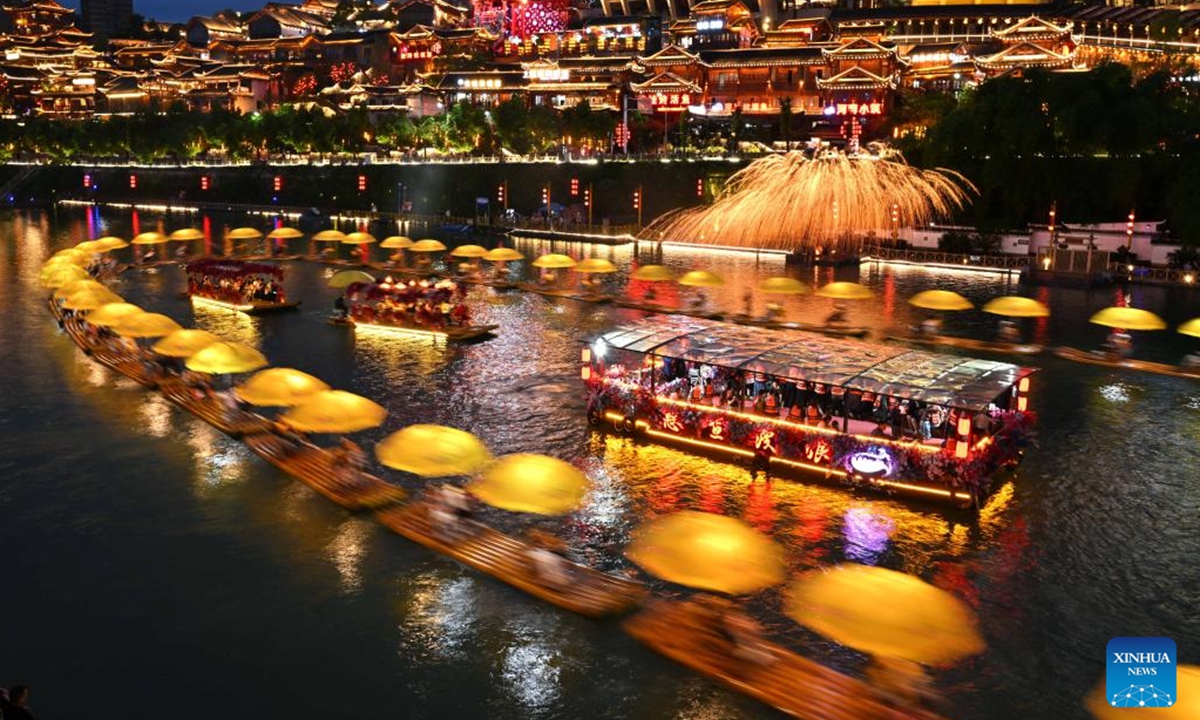 Tourists enjoy the night view along Gongshui River in Xuan'en County, central China's Hubei Province, June 1, 2025. People enjoy the 3-day holiday of the Dragon Boat Festival, also called Duanwu Festival which falls on May 31 this year, via various activities across the country. (Photo by Song Wen/Xinhua)