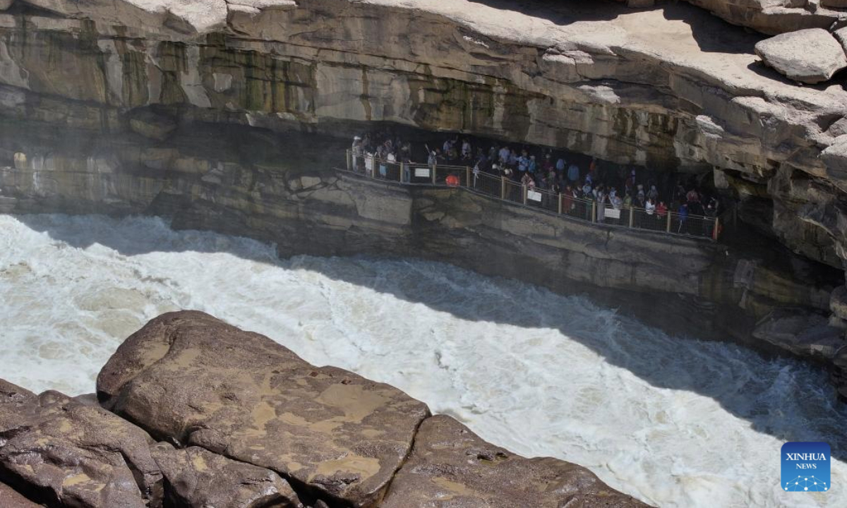 An aerial drone photo taken on June 4, 2025 shows tourists visiting the Hukou Waterfall on the Yellow River on the border between north China's Shanxi Province and northwest China's Shaanxi Province. (Xinhua/Zhang Bowen)