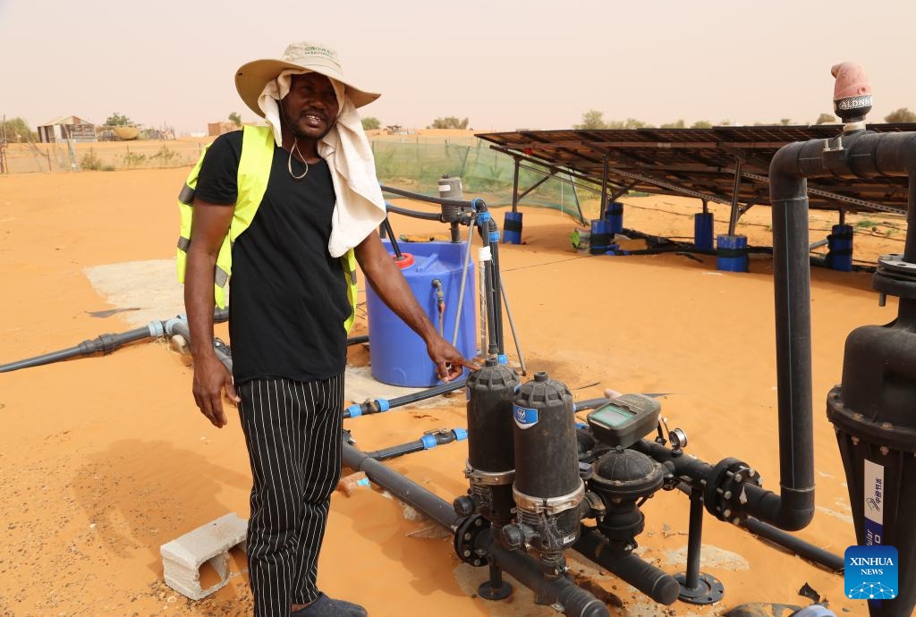 Mohamed Isselmou, the China-Africa Green Technology Park's irrigation system technician, introduces irrigation equipment in Bir El Barka, Trarza region, western Mauritania, on May 22, 2025. The China-Africa Green Technology Park is a key demonstration project supporting Africa's Great Green Wall Initiative, launched in 2007 to create a 7,000-km ecological barrier across northern Africa and the Sahel to combat desertification. (Xinhua/Si Yuan)