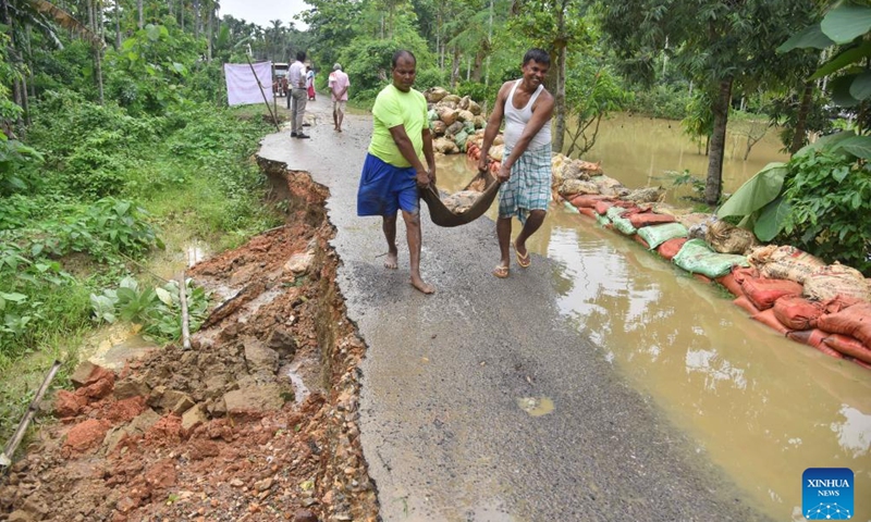 Workers repair a flood-damaged road after heavy rain in Nagaon district of India's northeastern state of Assam, June 2, 2025. (Str/Xinhua)